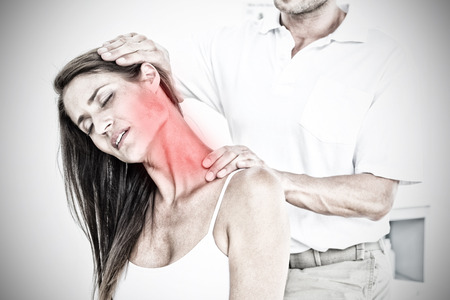 Highlighted pain against male chiropractor doing neck adjustmentの写真素材