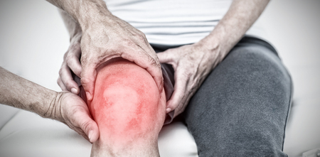 Highlighted pain against doctor examining his patients kneeの写真素材