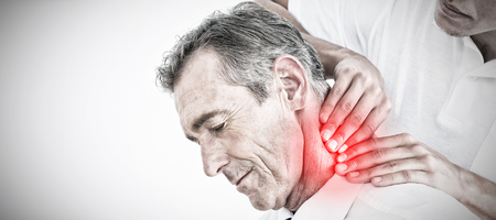 Male chiropractor massaging patients neck against highlighted painの写真素材
