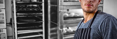 Male waiter standing against food kept in oven