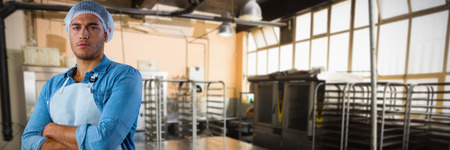 Male waiter standing with arms crossed against no one in the roomの写真素材