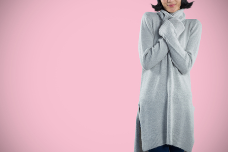 Woman in winter clothing posing against white background against pink backgroundの写真素材