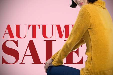 Woman in winter clothing posing against white background against pink backgroundの写真素材