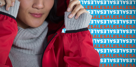 Smiling woman in hooded jacket standing against white background against blue backgroundの写真素材