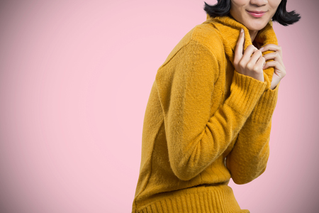 Woman in winter clothing posing against white background against pink backgroundの写真素材
