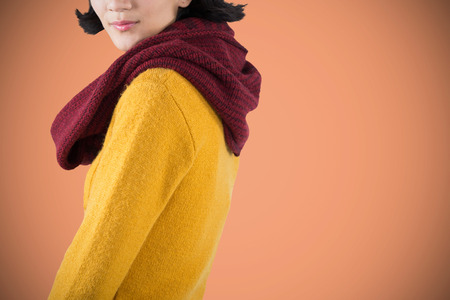 Woman in winter clothing posing against white background against orange backgroundの写真素材