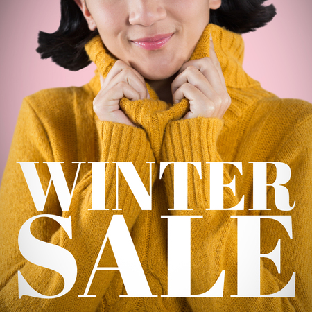 Woman in winter clothing posing against white background against pink backgroundの写真素材