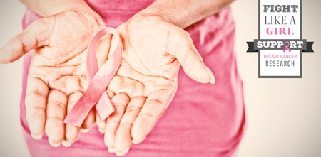 Breast cancer awareness message against woman holds ribbon in both hands for breast cancer awarenessの写真素材