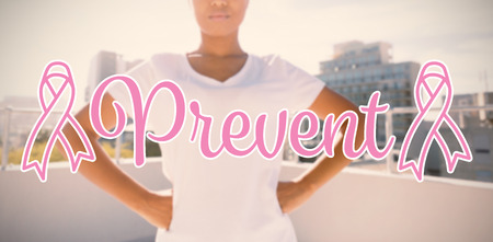 Prevent text with breast cancer awareness ribbon against strong woman standing for breast cancer awarenessの写真素材