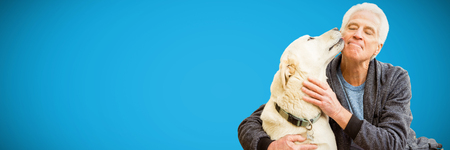 Man playing with his pet dog against blue background
