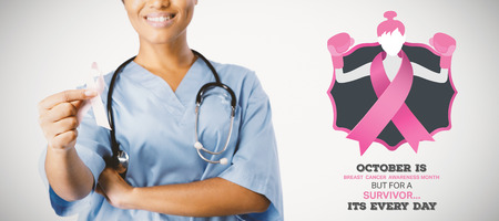 Breast cancer awareness message against smiling nurse hold breast cancer awareness pink ribbonの写真素材