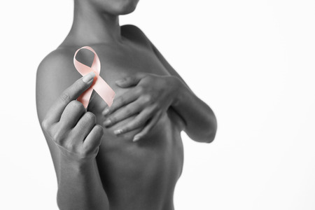 Shirtless woman for breast cancer awareness with ribbon on white backgroundの写真素材