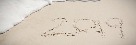 2019 written in the sand with waves coming in