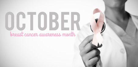 Pink breast cancer awareness text against breast cancer awareness pink ribbon on a stethoscopeの写真素材