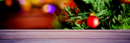 Snow falling against multi colored bauble decorations on christmas tree