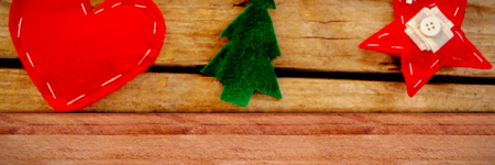 Snow falling against close up of various shapes christmas decoration hanging on rope on wallの写真素材