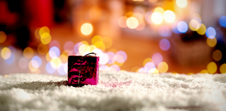 Copy space with gift and snow against defocused of christmas tree lights and fireplaceの写真素材