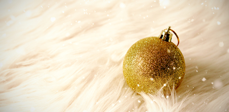 Snow falling against christmas ball on a carpetの写真素材