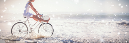Snow falling against woman riding bikeの写真素材