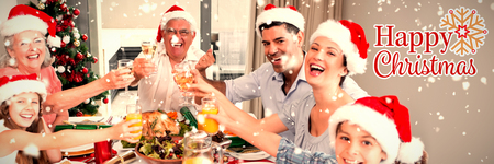 Family in santas hats toasting wine glasses at dining table against christmas cardの写真素材