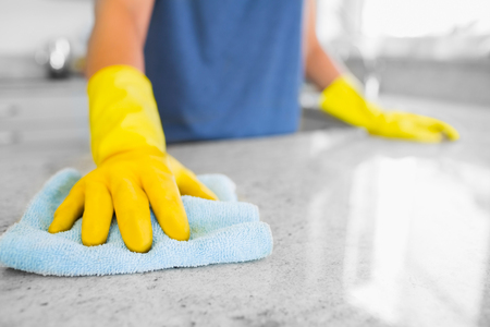 Woman cleaning the counter in the kitchenの写真素材