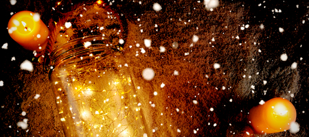 Snow falling against yellow candles and smooth christmas lightsの写真素材