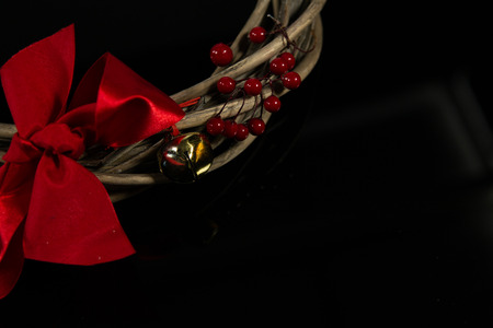 Christmas branches crown with red ribbon on a dark backgrondの写真素材
