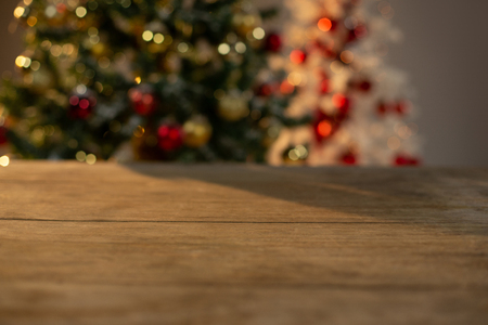 Close-up of wooden table with Christmas tree in backgroundの写真素材