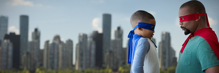 Father and son pretending to be superhero against skyline at the river coastの写真素材