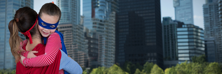 Mother and daughter pretending to be superhero against cityの写真素材