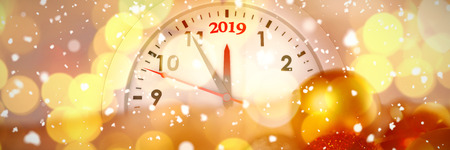 Snow falling against defocused of christmas tree lights and clock