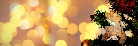 Defocused of Christmas tree lights and fireplace against christmas ornaments hanging in tree with copy spaceの写真素材