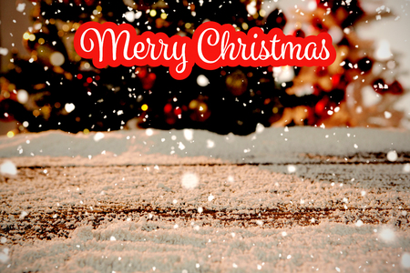 White and red greeting against wooden table covered in snowの写真素材