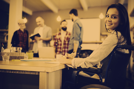 Portrait of confident disabled businesswoman writing at desk in creative officeの写真素材