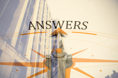 Compass with answers text against view of office building against blue skyの写真素材