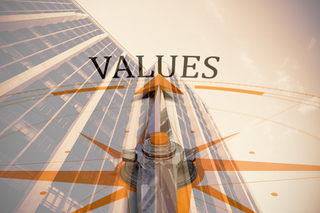 Values against compass against low angle view of office building against blue skyの写真素材