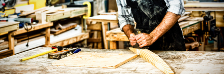 Carpenter working on his craft in dusty workshop
