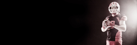 American football player in helmet holding rugby ballの写真素材