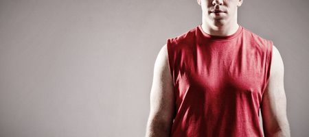 Portrait of American football player standing against grey backgroundの写真素材