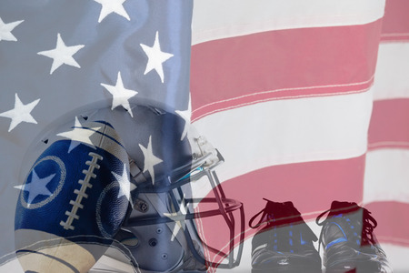 Close up of America football and helmet by sports shoes against close-up of an american flagの写真素材