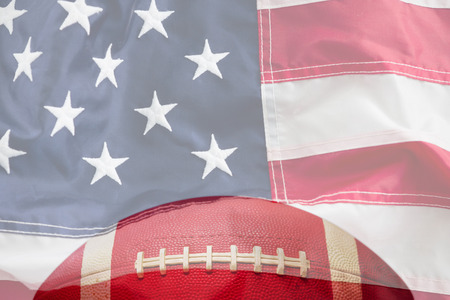 Brown American football against full frame of american flagの写真素材