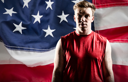 Volleyball player standing against full frame of american flagの写真素材