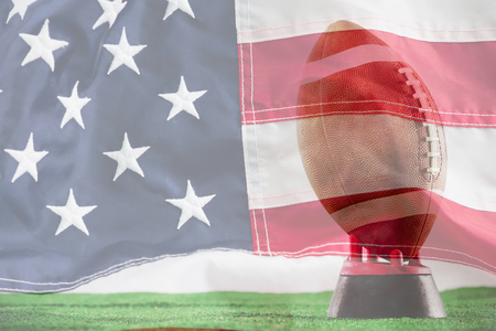 American football on tee against white background against full frame of american flagの写真素材