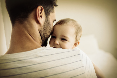Father holding his baby girl at homeの写真素材