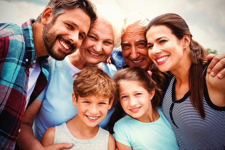 Portrait of happy multi generation family standing against skyの写真素材