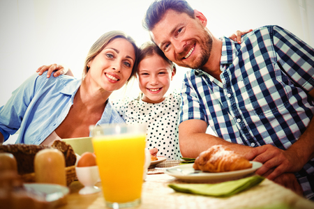 Portrait of happy family having breakfast together at homeの写真素材