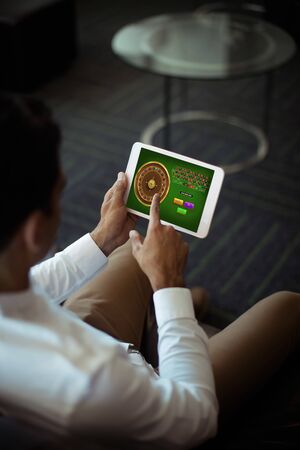 Online Roulette Game  against businessman using digital tablet at officeの写真素材