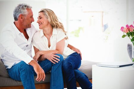 Romantic mature couple sitting face to face at homeの写真素材
