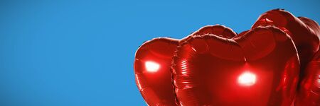 Red heart shape balloons against blue backgroundの写真素材