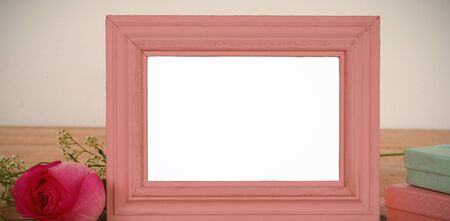 Empty photo frame, rose flower and gift boxes on a tableの写真素材